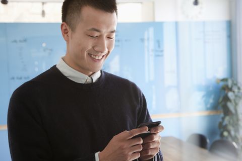 Happy man texting on his phone